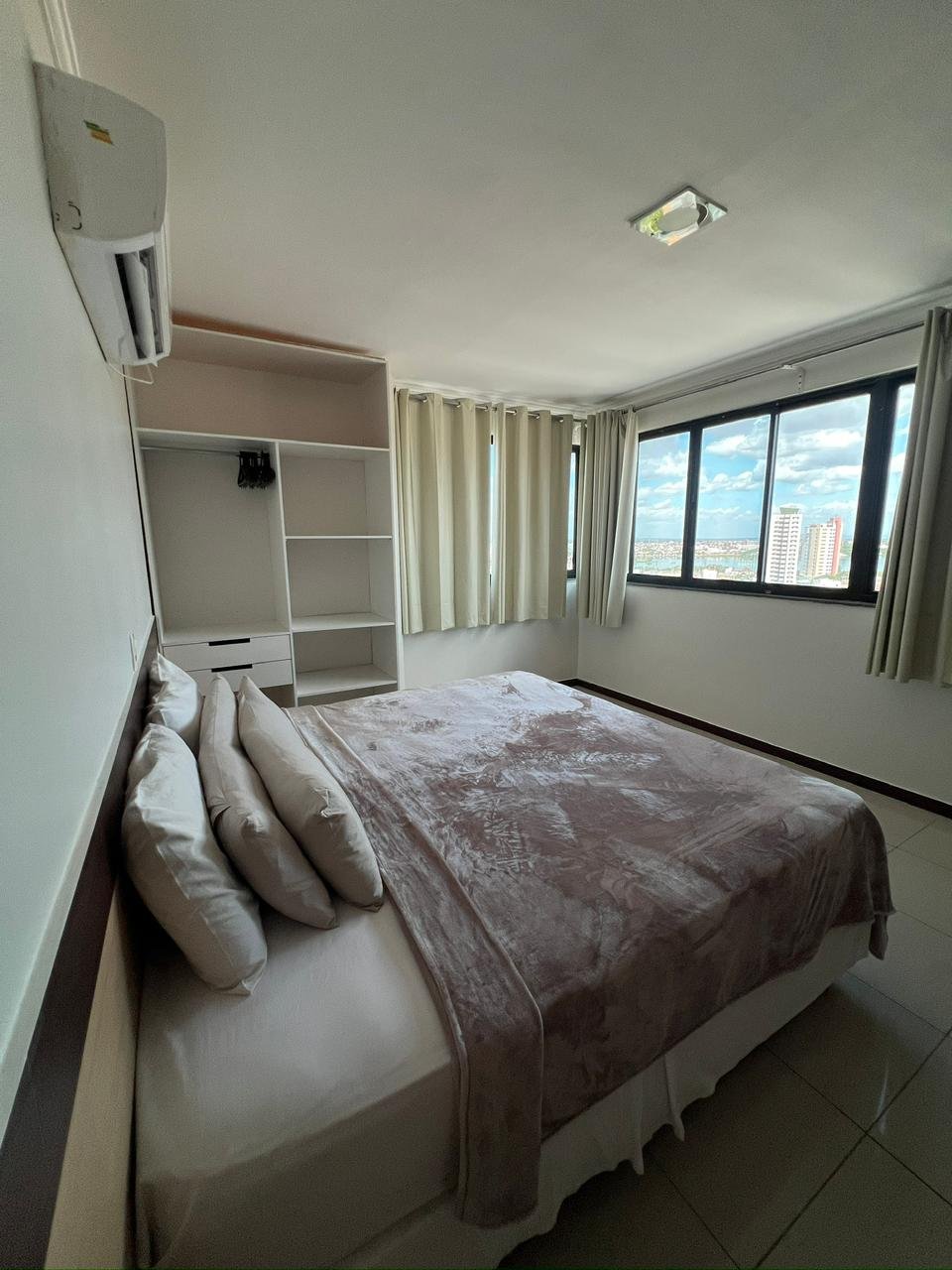 Acomodação do Águas Palace com cama de casal, janela e ar-condicionado